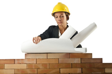 Businesswoman with drawings near brick wall