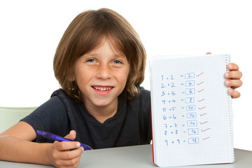 Cute kid showing notebook with math problems.