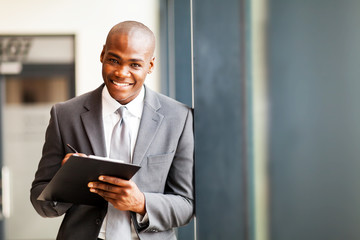 african american businessman writing report in office