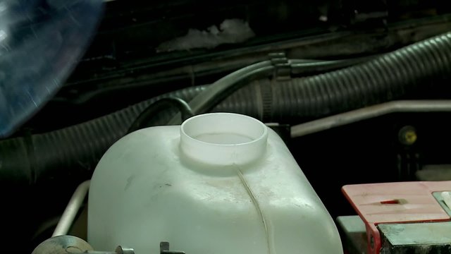 Pouring the windshield washer fluid into the tank