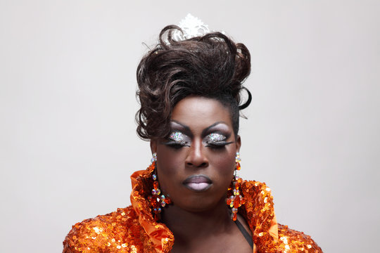 Drag queen wearing an orange gown with sequins.