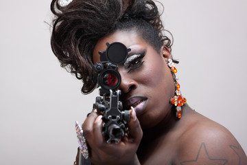 Drag queen aiming an assault rifle.