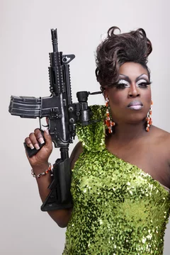 Drag queen wearing a green gown holding an assault rifle. Stock Photo |  Adobe Stock