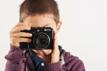 Child with digital compact camera, isolated on white background.