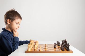 Child playing chess, isolated on white background.