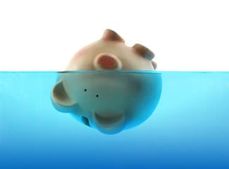 Piggy bank sinking in blue water