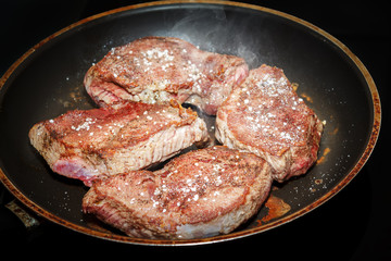 beef meat on pan with pepper and sea salt