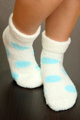 Legs female in socks with polka dots on laminate floor