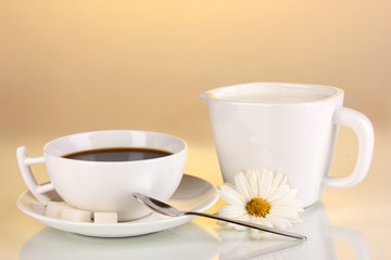 A cup of strong coffee and sweet cream on yellow background