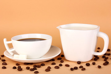 A cup of strong coffee and sweet cream on beige background