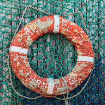 Old weathered lifebuoy on wooden wall