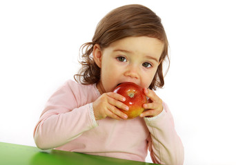 Ein Mädchen beißt in einen roten Apfel