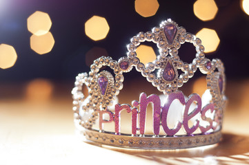 Princess tiara toy sparkling against background bokeh lights. © Alex Hinds