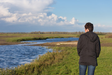 Naklejka na ściany i meble Woman in a beautiful wetland landscape in the Netherlands