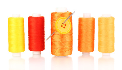 Many yellow bobbin with needle and buttons isolated on white