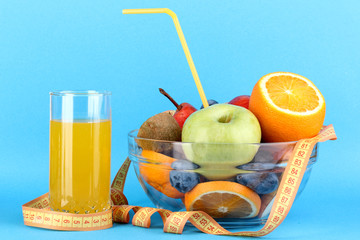 Glass bowl with fruit for diet and juice on blue background