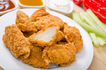 Chicken nuggets with vegetables and three dipping sauces.