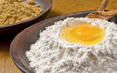 A bowl of flour with egg well.