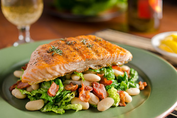 Grilled salmon with white beans, kale, and bacon.