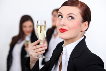 Females coworkers drinking champagne.