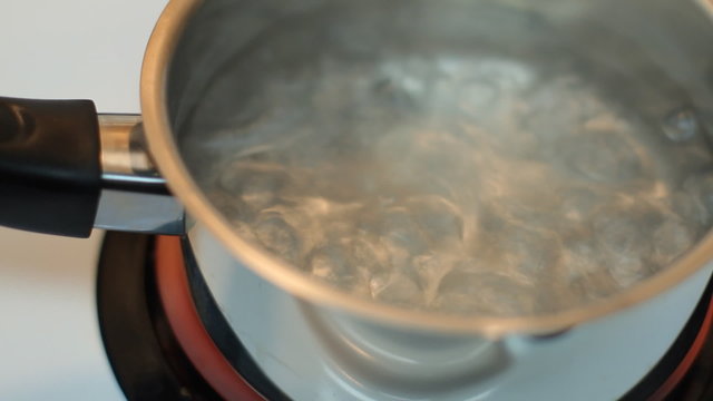 Pot full of boiling water on the electric stove.