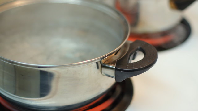 Pot full of boiling water on the electric stove.