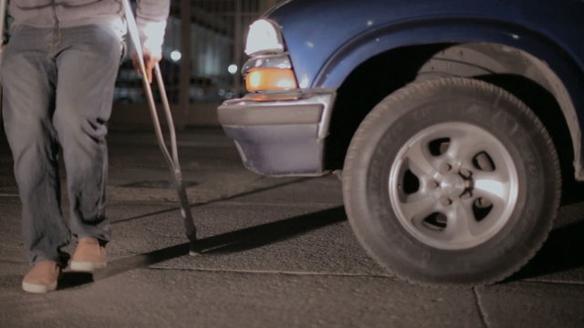 Man on crutches crossing the street