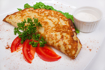 Stuffed pancake with sour cream