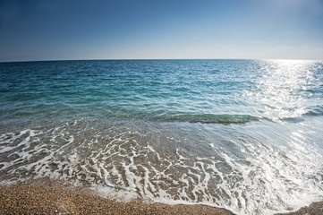 Fototapeta na wymiar Splash z morskiej piany na piaszczystej plaży