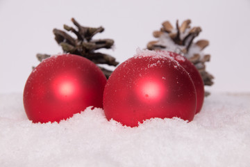 Fototapeta na wymiar Weihnachtskugeln rot Schnee Tannenzapfen