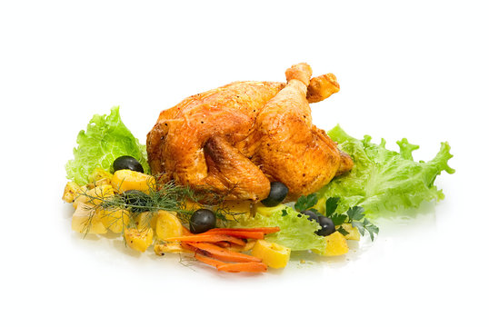 Whole roasted chicken with vegetables on a white