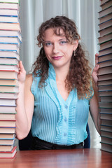 Young student woman with lots of books studying for exams.