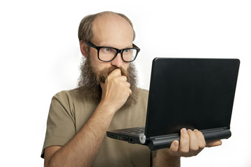 Bearded man looking and thinking at laptop