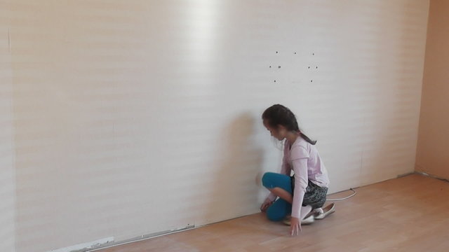 irl removing a wallpaper in house.