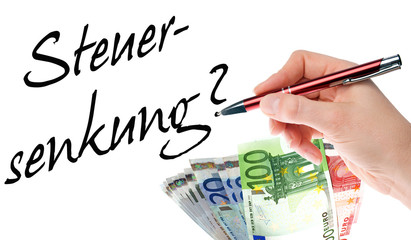 Hand mit Stift schreibt das Wort Steuersenkung