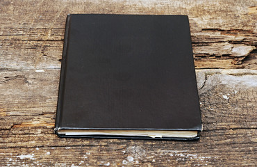 black leather notebook on wooden background