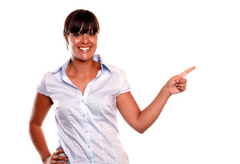 Smiling young woman looking at you pointing left