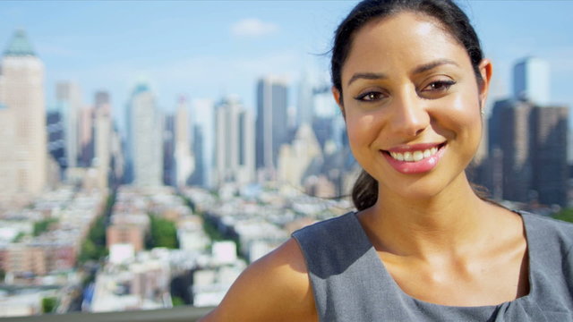 Portrait of beautiful Hispanic manager on rooftop overlooking city 
