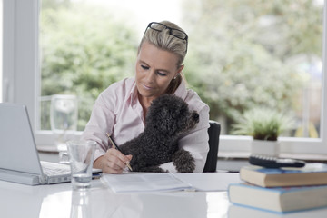 Woman working from home with a dog in her arms2