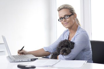 Woman working from home with a dog in her arms3