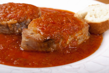 Tuna fish in tomato sauce and a slice of bread.