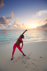 Fototapeta na wymiar Woman stretching on beach