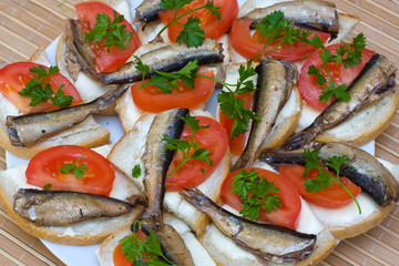 Sandwiches with sprats on a plate