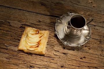 silver cup of teaand sliced apple on pastry food