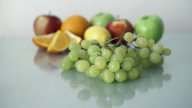 Green grapes falling on glass surface,slow motion shot at 480fps