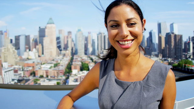 Portrait of Hispanic female business manager on rooftop overlooking Manhattan
