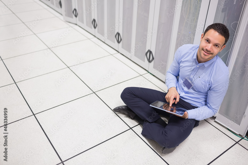 Aufkleber man using tablet pc sitting beside servers