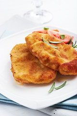 Wiener schnitzel with rosemary on a white plate