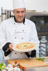 Cheerful chef presenting pizza