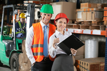Two Confident Young Supervisors At Warehouse